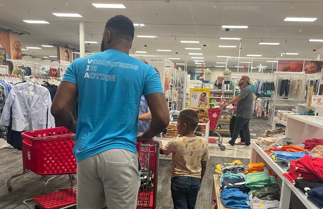 Volunteer pushing a cart during a shopping spree for Child Advocates